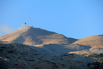 Military Radars On Mountain Peak Under Clear Blue Sky With Golden Grass And Trees, Golan Heights,...