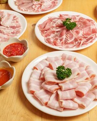 Freshly Sliced Pork and Sauces Served on Plates in a Restaurant Setting