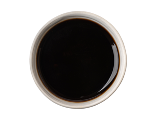 Small bowl containing soy sauce viewed from above on white background