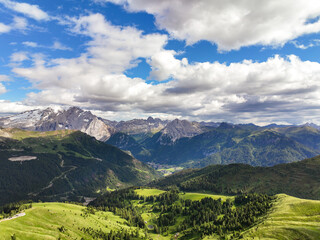 Dolomites mountains Italy Alps at dawn on sunny day in summer against blue sky. Grandeur mountain range. Aerial view panning shot of beautiful Dolomite Mountain range. Tavel tourism concept