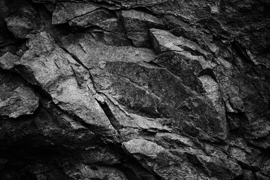 Black white dark gray stone rock granite background. Mountain surface texture. Close-up. For design.