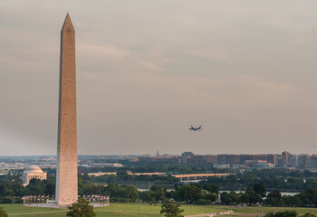 Cityscape of Washington, DC with view of the Washington Monument and airplane flying.