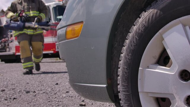 Fire figher with jaws of life approaching car wreck