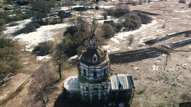 Flying around the ruined old stone church in the early spring landscape