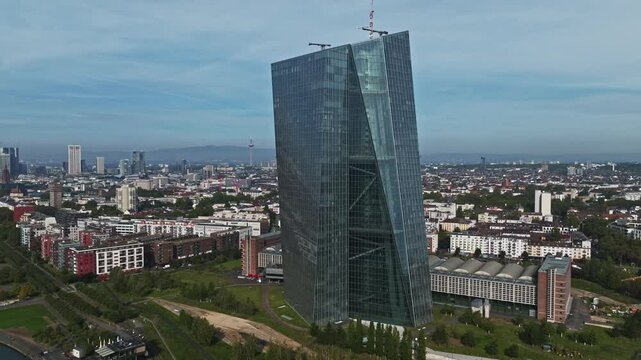Aerial Drone View of the European Central Bank (Europ&auml;ische Zentralbank), Located Along the Main River in Frankfurt, Germany &ndash; Striking Glass and Steel Skyscraper with a Unique Twisted Design
