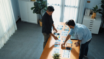 Top view of front-end developer design Ux Ui design for mobile phone interface with multicultural team. Professional smart designer walking and joining meeting while planning application. Convocation.