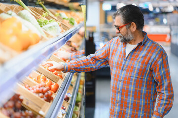 Mature senor in the vegetables section of the supermarket