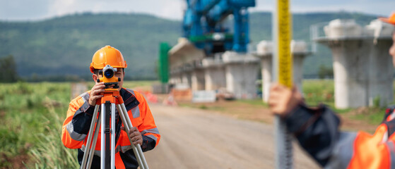 Survey team is working with a theodolite and road construction plans. Civil engineers are taking...