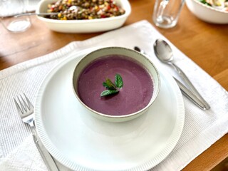 Healthy creamy red cabbage soup topped with herbs