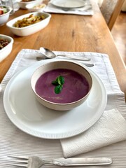 Healthy creamy red cabbage soup topped with herbs