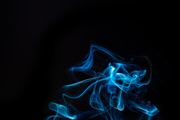 Blue smoke swirls in abstract form, photography style on black background. Concept of mystery and creativity