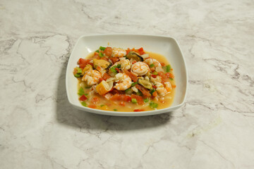 A white plate with shrimp and vegetables