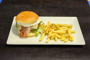 A plate of a hamburger and fries sits on a table