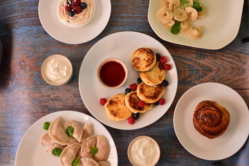 A table with a variety of pastries and desserts, including a cake, a donut
