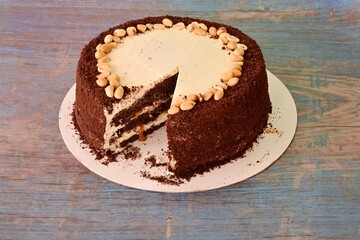 A cake with a piece missing and nuts on top