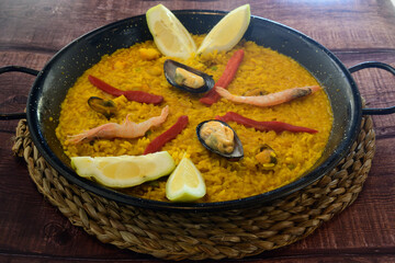 A bowl of food with a lemon wedge and shrimp on top