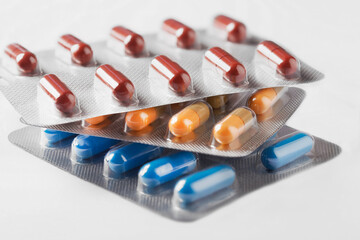 colored medical pills blue yellow on white background