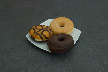 Three donuts on a white plate