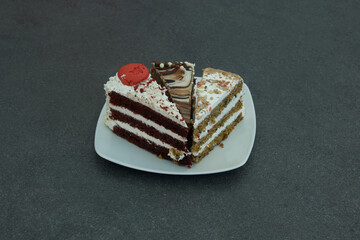 Three slices of cake on a white plate