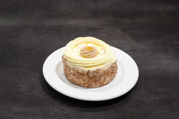 A small white cake with a yellow frosting
