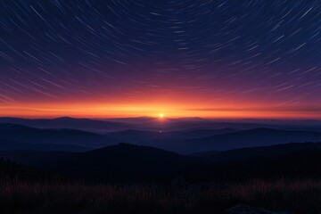 Obraz premium A breathtaking sunrise paints the sky with vibrant colors as stars leave trails across the mountain range.