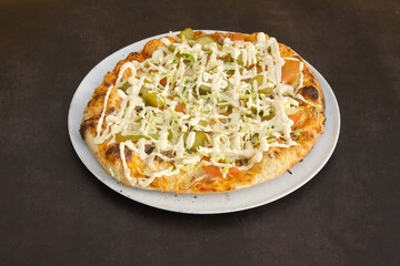 A pizza with cheese and vegetables on top of a white plate