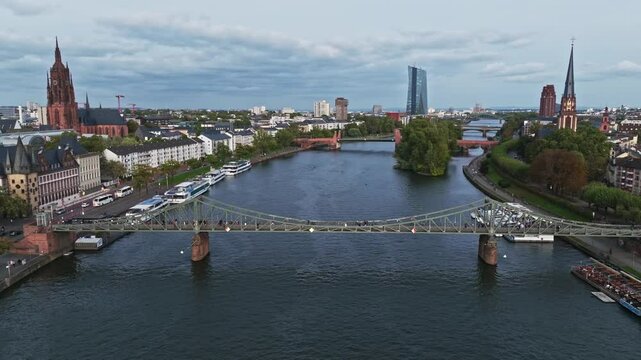 Aerial Drone View of the Iron Footbridge (Eiserner Steg) in Frankfurt, Germany &ndash; Historic Pedestrian Bridge Spanning the Main River, Offering Scenic Views of the City Skyline, Waterfront, and Cultural