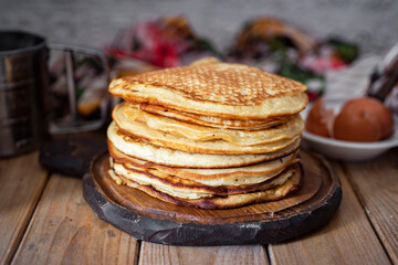Delicious dessert: a stack of thin large pancakes for breakfast on a gray background. Close-up