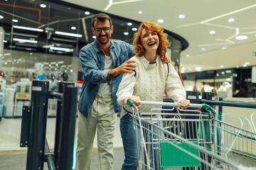 Happy couple leaving supermarket with shopping cart © Zamrznuti tonovi