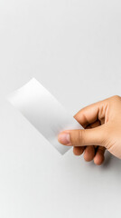 Hand holding blank business card against light background