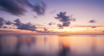 Obraz premium Serene Sunset Ocean Reflection - Peaceful sunset over calm ocean waters, clouds reflecting in the tranquil sea. Colors of orange, purple, and pink fill the sky