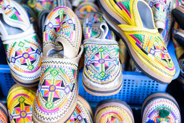 Colorful Vibrant leather handmade Moroccan slippers, babouches for sale in traditional local souk, story heritage and authentic oriental craftsmanship, artisanal culture Morocco