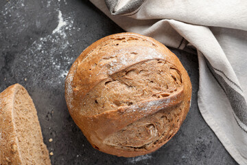 Whole and cut fresh bread on grey table, top view