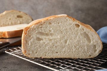 Cut fresh bread on grey table, closeup
