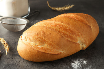 Freshly baked bread, spikes and sieve on grey table, closeup