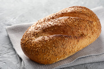 Freshly baked bread with seeds on grey table, closeup