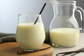 Delicious vanilla milk and pods on grey table