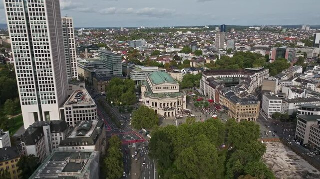 Aerial drone view of Alte Oper in front of Opernplatz, Frankfurt, Germany, showcasing the historic opera house surrounded by modern skyscrapers and urban architecture.
