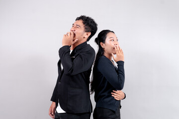 Asian man and woman laughing with hands covering mouths, standing back to back. They express joy, humor, and a fun, playful moment, symbolizing happiness and positive emotions.