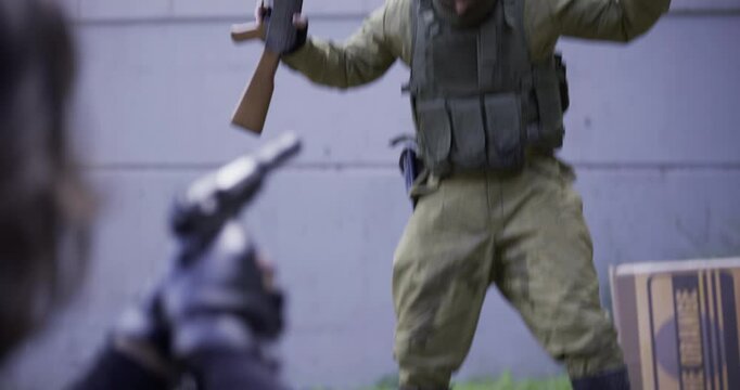 Spy pointing gun at guard who holds his hands and gun in the air as he pees his pants