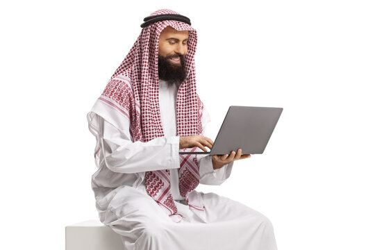 Saudi arab man sitting and using a laptop computer
