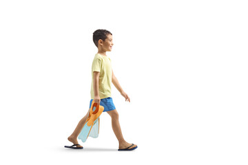 Kid carrying a pair of snorkeling fins and walking