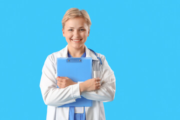 Female medical intern with clipboard on blue background