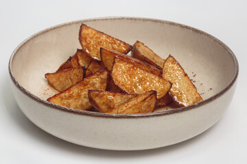 The image shows a plate of crispy, golden-brown potato wedges. 