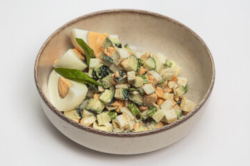 The salad is served in a light-colored, rustic-style bowl with a darker brown rim, giving it an earthy, homemade appearance. 