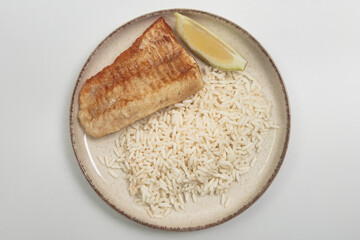 This image shows a simple yet appetizing meal of fried fish and white rice. 