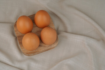  Brown eggs on wooden tray.