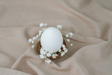 White egg in floral nest. Easter egg. Easter backgorund.