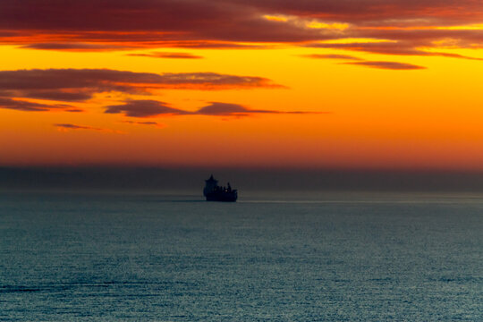 Sunrise at the cruise port of Quetzal in Guatemala. Two ships can be seen as dark silhouettes on the water.