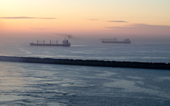 View of the Pacific Ocean in the harbor at sunrise; some ships are visible.